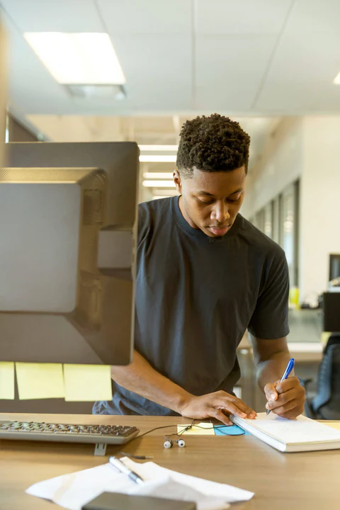 A student working through physics problems at a desk